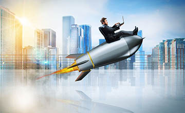 Computer user sitting on a rocket blasting off